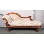 A Victorian carved mahogany chaise lounge.