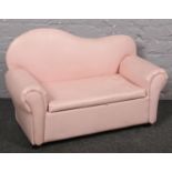 A miniature pink leatherette child's settee, 83cm wide.