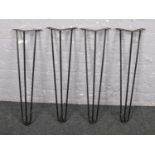 A set of four black painted metal hairpin furniture supports (71cm).