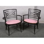 A pair of small ebonised arm chairs.