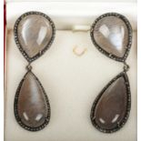 A pair of silver mounted rutilated quartz drop earrings, each with two pear formed quartz stones