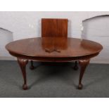 A Victorian mahogany wind out table, raised on carved ball and claw supports with extra leaf and