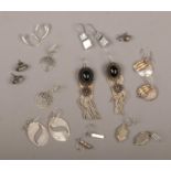 Ten pairs of silver earrings.