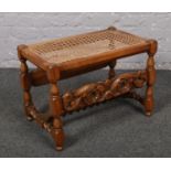 A carved mahogany stool, with bergere seat and barley twist supports.