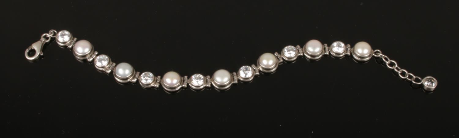 A silver, cubic zirconia and culture pearl line bracelet.