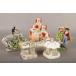 A collection of Staffordshire pottery including two cottage pastille burners, flatback zebra,