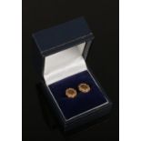 A pair of 9ct gold ear studs with engine turned engraving.