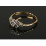 An 18ct gold and platinum diamond crossover ring. Size S, 2.48g gross weight.