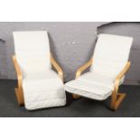 A pair of modern easy arm chairs.