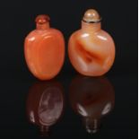 Two 18th century Chinese carved orange agate snuff bottles and stoppers. Both well hollowed and