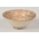 An antique Islamic pottery bowl. Buff ground and with stylized brown decoration, 19cm diameter.