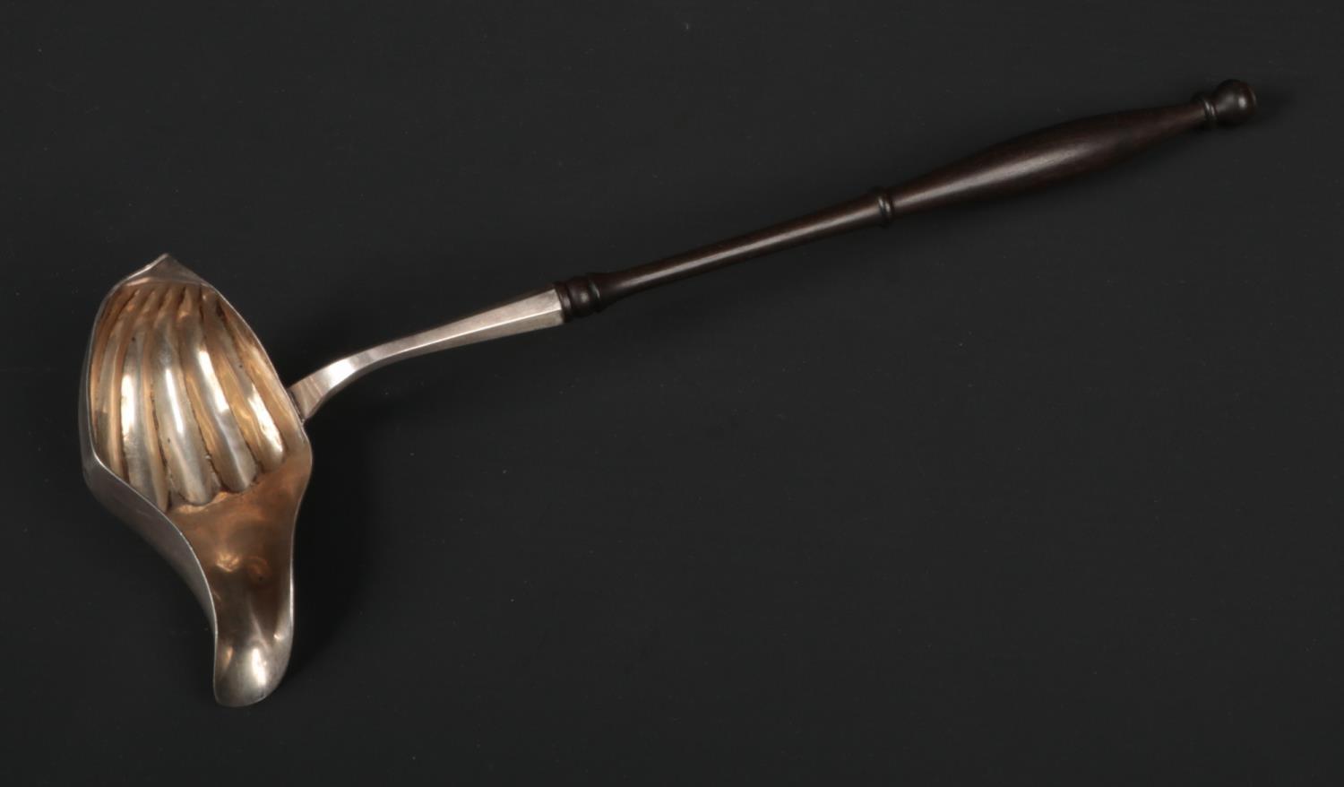 A 19th century Continental silver toddy ladel. With turned hardwood handle and shell moulded bowl.