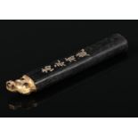 A 19th century Chinese calligraphy ink stick. With a gilt decorated dog of fo finial and incised