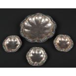 A set of four early 20th century Russian style lobed silver dishes. Planished, with champleve enamel