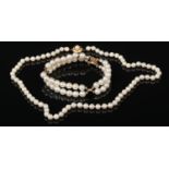 A pearl necklace with 14 carat gold clasp and a similar two row bracelet, unmarked.