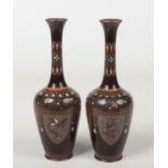 A pair of Japanese Meiji period cloisonne bottle vases. Black and red speckle ground and with panels