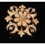 A cased 18 carat gold, diamond and pearl starburst brooch. Set with five round cut diamonds,