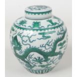 A Chinese ginger jar and cover. Painted in underglaze blue and green with three dragons chasing