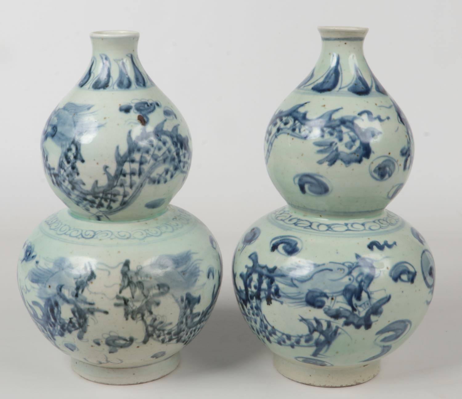 A pair of 20th century Chinese blue and white double gourd vases. Painted in underglaze blue with