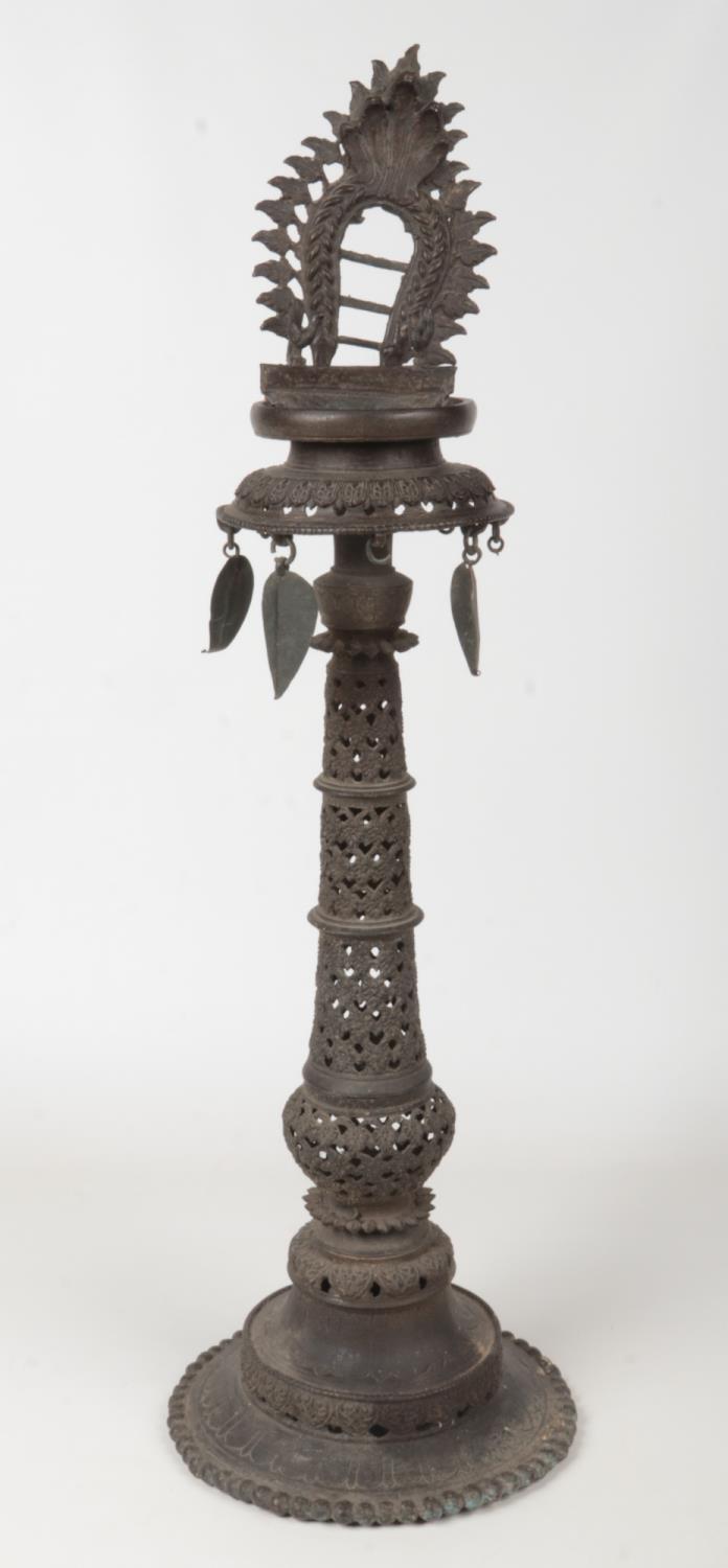 A 19th century Tibetan bronze alter stand with pierced decoration and hanging leaf formed drops,