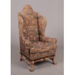 A good 19th century wing armchair with oak frame in Queen Anne style. With domed high-back, original