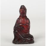 A 19th century Chinese carved amber figure of Guanyin seated. Dressed in a flowing robe and