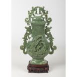 A 20th century Chinese carved jade urn and cover raised on hardwood plinth. With flat open scroll