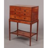 A Regency satinwood collectors specimen cabinet on stand. With ebonized mouldings, strung inlay