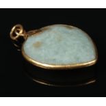 A jade coloured hardstone pendant of peach form with yellow metal mount, 4cm. Some marks to the