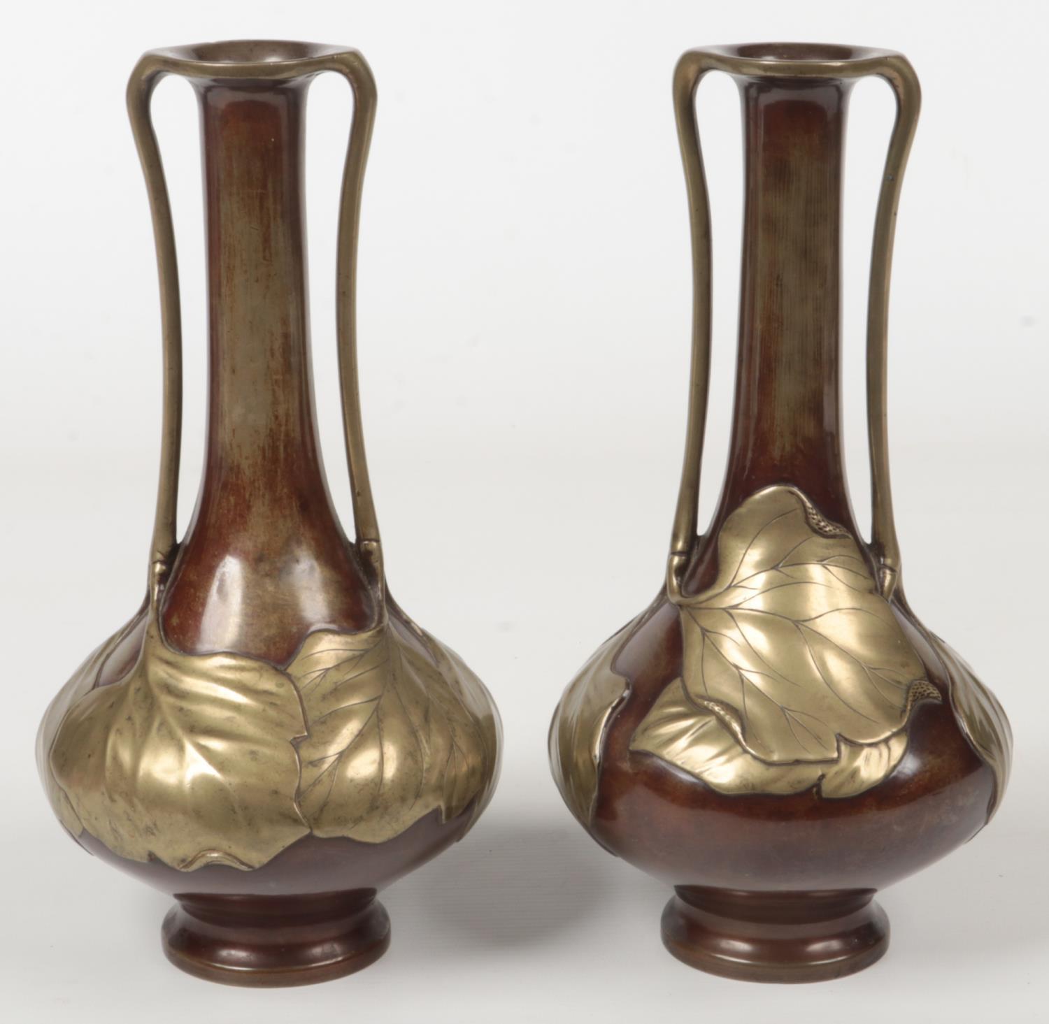 A pair of Japanese Meiji period bronze overlay twin handled vases of tall slender form. Decorated in