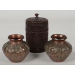 A 19th century Indian carved hardwood lidded jar decorated with stylized leaves and two copper