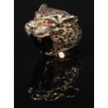 A heavy cast silver ring formed as a leopards head clutching a large faceted ovoid black diamond