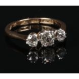 An 18 carat gold and platinum three stone diamond ring. Set with three old European cut diamonds.