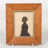 A Regency silhouette miniature in maple frame. Portrait of a girl with ringlets and embellished in