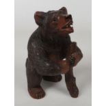 An early 20th century Black Forest carved figural tobacco jar in the form of a bear. Having glass