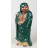 A Japanese Meiji period earthenware figure of Bodhidharma decorated in coloured enamels. Stood