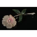 An 18 carat white gold, hardstone and diamond brooch of flower form in case. Formed as a peony