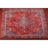 An Iranian Najafabad wool carpet. Red ground and with a central floral medallion, 250cm x 350cm.