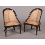A pair of 19th century Anglo-Colonial ebony chairs with canework seats and raised on turned
