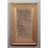 A 19th century giltwood and gesso framed woolwork embroidery panel depicting flowers and foliage,