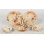 A Royal Worcester figural spill vase by James Hadley formed as a figure playing a banjo. Along
