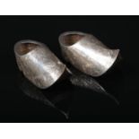 A pair of Dutch silver miniature clogs decorated in relief with scrolls. Stamped BXV12, 6.5cm.