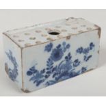 An 18th century Delft flower brick. Painted in blue with flowers issuing from rocks in the