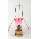 A Victorian hanging brass oil lamp with cranberry glass shade., 83cm. Glass in good condition. No
