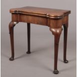 A George II mahogany fold over tea table. Raised on plain cabriole supports terminating on pad feet,