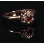 A 19th century gold, diamond and ruby cluster ring. Set with six rose cut diamonds around a