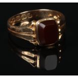 A Victorian 18 carat gold carnelian signet ring. Set with a cushion shaped tablet on reeded