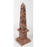 A carved black and russet marble obelisk. With four sphere supports and raised on a stepped