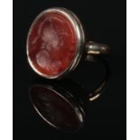 A 19th century yellow metal and carnelian intaglio seal ring. The matrix carved with the profile