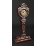 An Edwardian silver mounted mahogany pedestal mantel clock by W J Myatt & Co. Decorated in relief